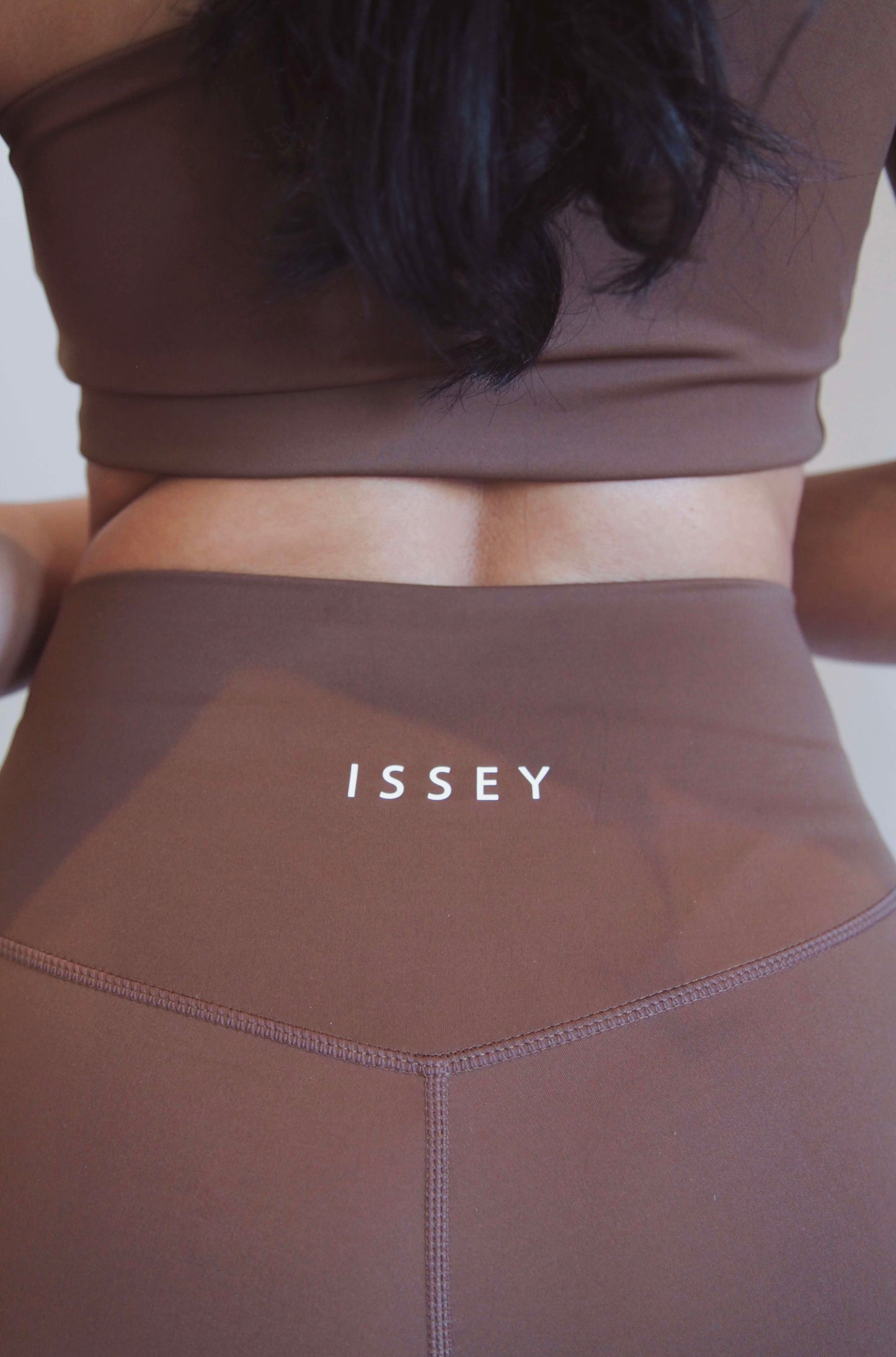 detail shot of the logo, back of brown high waist leggings