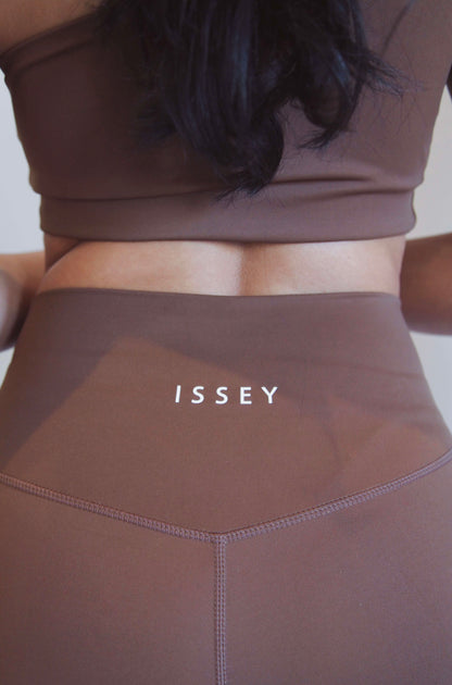 detail shot of the logo, back of brown high waist leggings